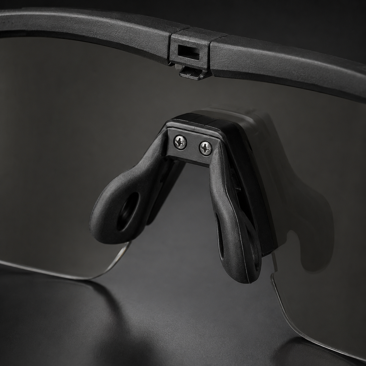Close-up of tactical goggles adjustable nose pad, black frame, transparent lenses, showing anti-slip design, protective eyewear for outdoor and CS.