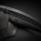 Close-up of tactical goggles temple arm texture, black frame, showing anti-slip details, transparent lenses, adjustable nose pad, protective eyewear for CS and outdoor use.