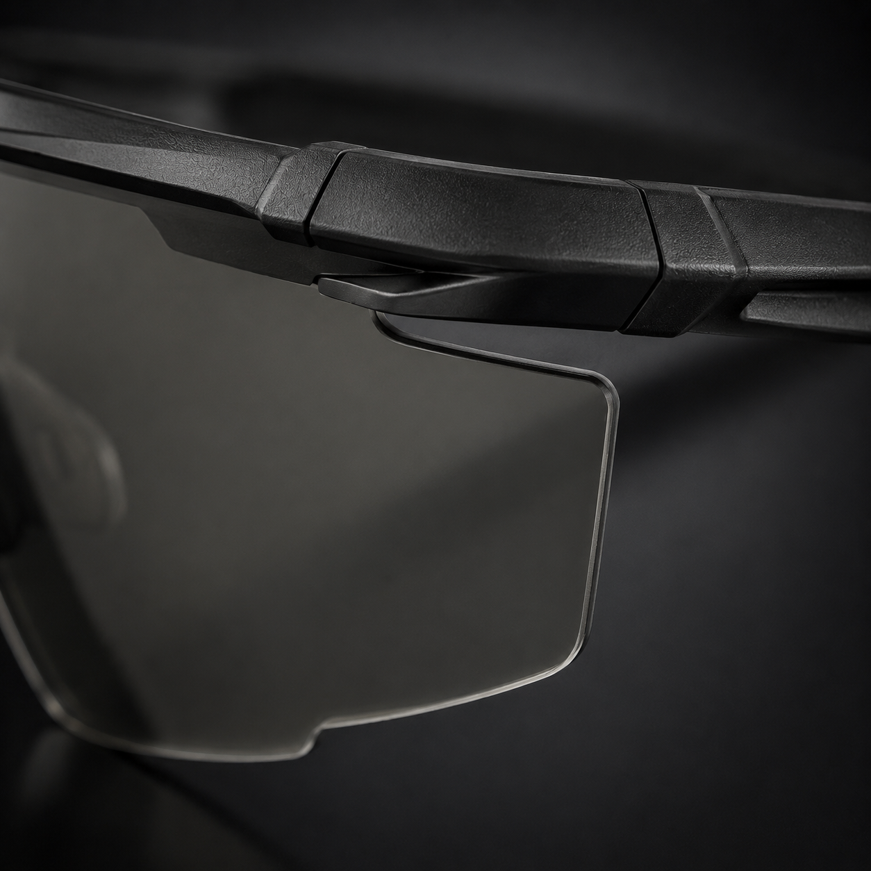 Close-up of tactical goggles lens edge, black frame, transparent lenses, precise frame-to-lens connection, adjustable nose pad, protective eyewear for CS and outdoor use.