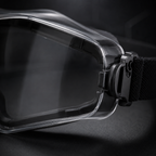 Close-up of the black tactical goggles front corner, emphasizing lens-frame junction, lens transparency, frame contour, and premium material texture. Dark tech-inspired ecommerce background, anti-fog protective eyewear.